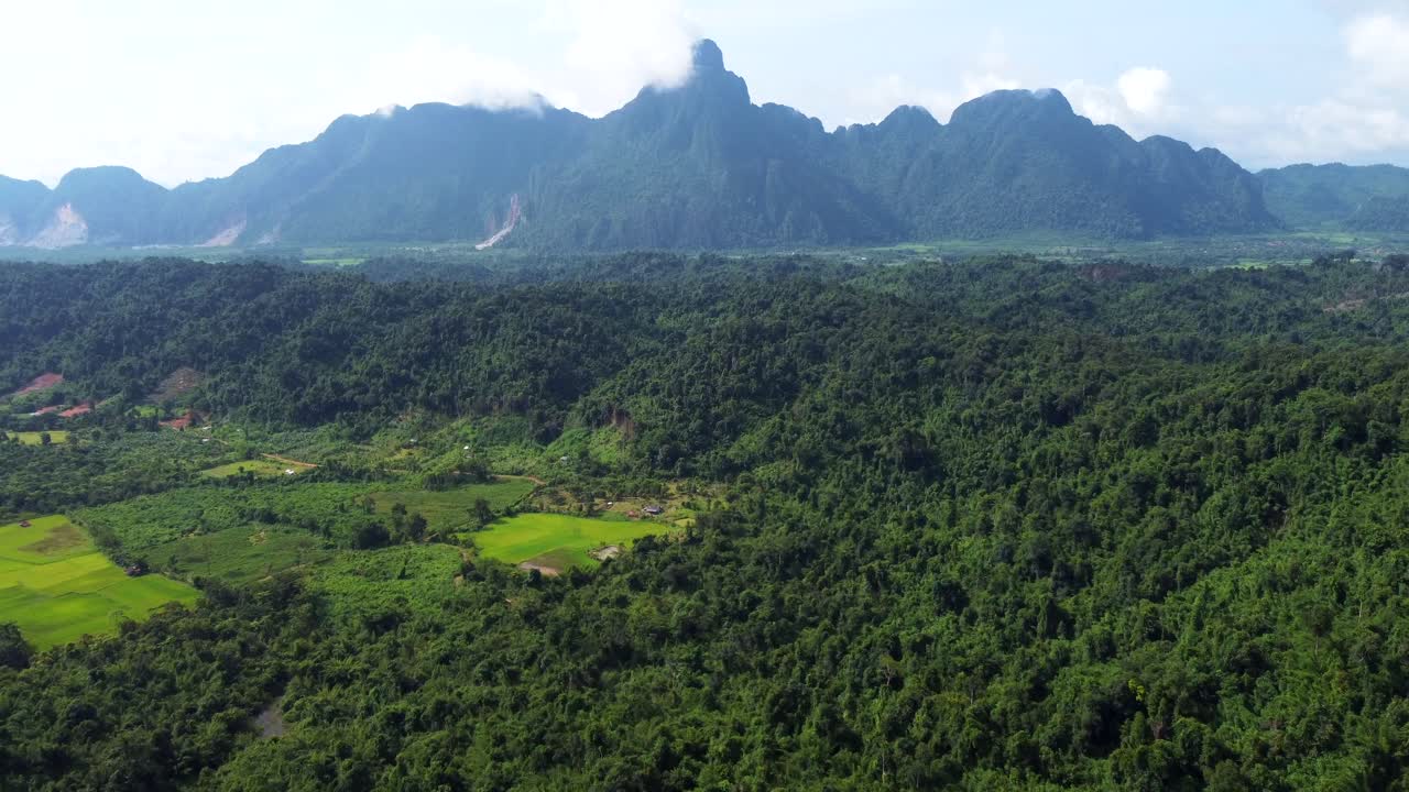 Catena montuosa vicino a Naka in Laos e un vasto campo verde in una giornata nuvolosa