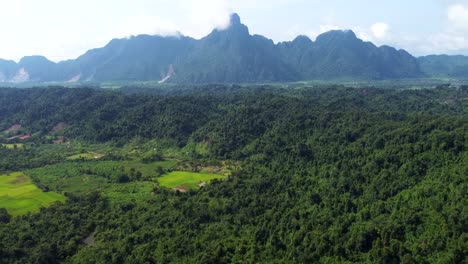 mountain range near naka in laos, and a vast green field on a cloudy day