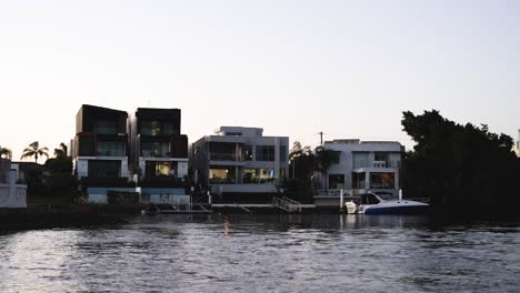 boat cruising past luxury waterfront homes at sunset