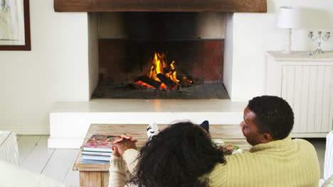 couple sitting on sofa in lounge next to open fire