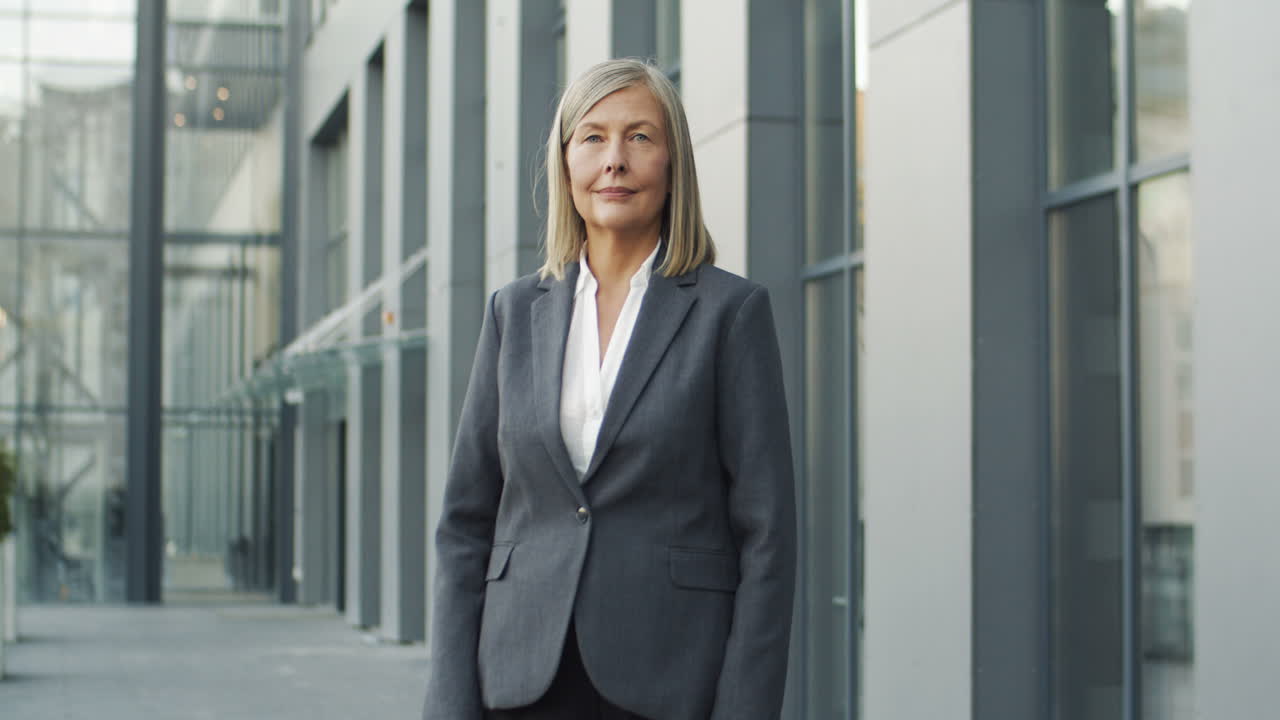 mujer de negocios madura en la calle y mirando a la cámara con los brazos cruzados