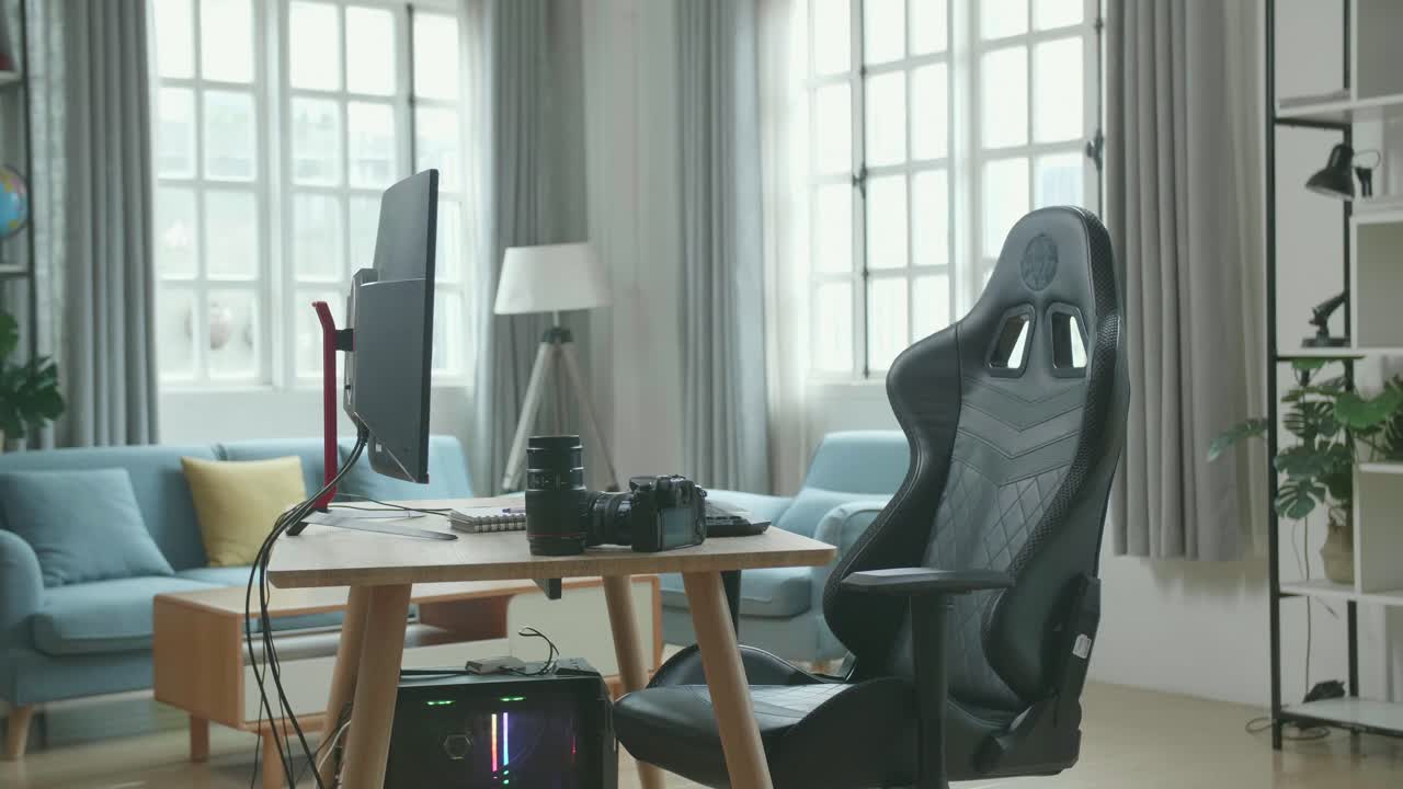 Desktop Computer And Camera On A Table With A Chair In The Working Room At Home.