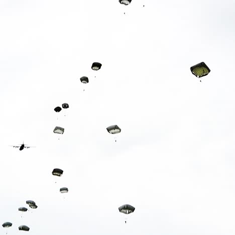 Fallschirmjäger,-Die-Aus-Einem-Flugzeug-Aus-Der-Zeit-Des-Zweiten-Weltkriegs-In-Der-Nähe-Von-Saintemereeglise,-Frankreich,-Zum-75.-Gedenken-An-Den-9.-Juni-2019-Springen