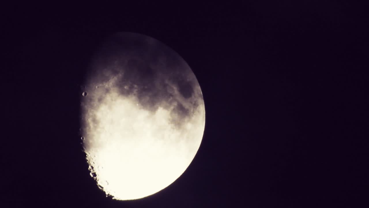 luna por la noche con nubes en tiempo real. 4k video luna en el cielo negro. nubes pasando por la luna por la noite. cielo nocturno con tiempo nublado
