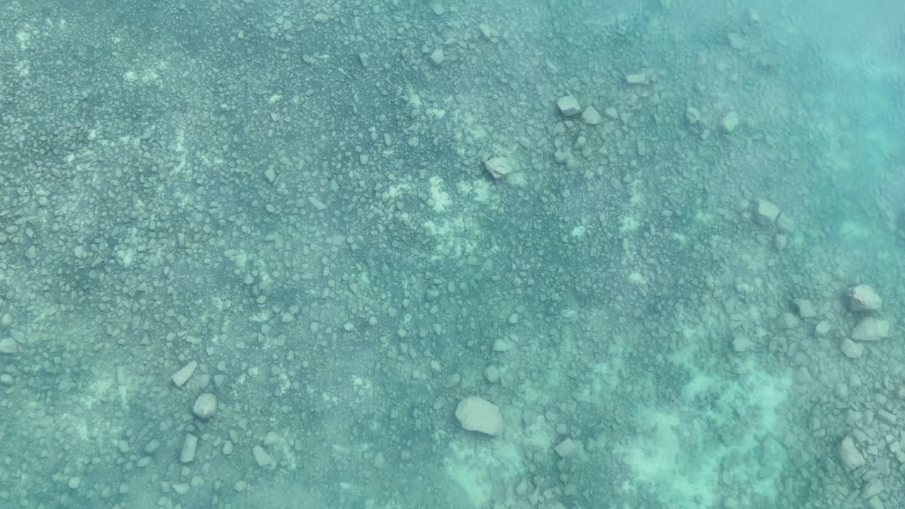 Un filmato drone cattura le acque serene, poco profonde e cristalline del Lago Tekapo, mostrando la sua bellezza naturale dall'alto