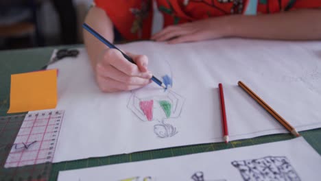 caucasian woman drawing in fashion office