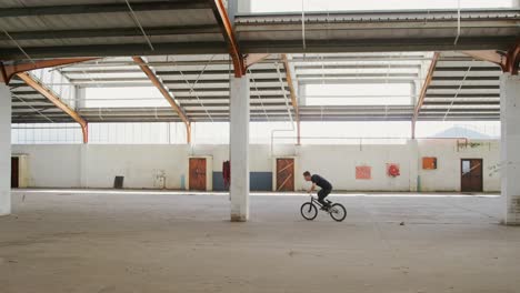 BMX-Fahrer-In-Einem-Leeren-Lagerhaus