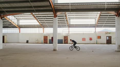 bmx rider in an empty warehouse