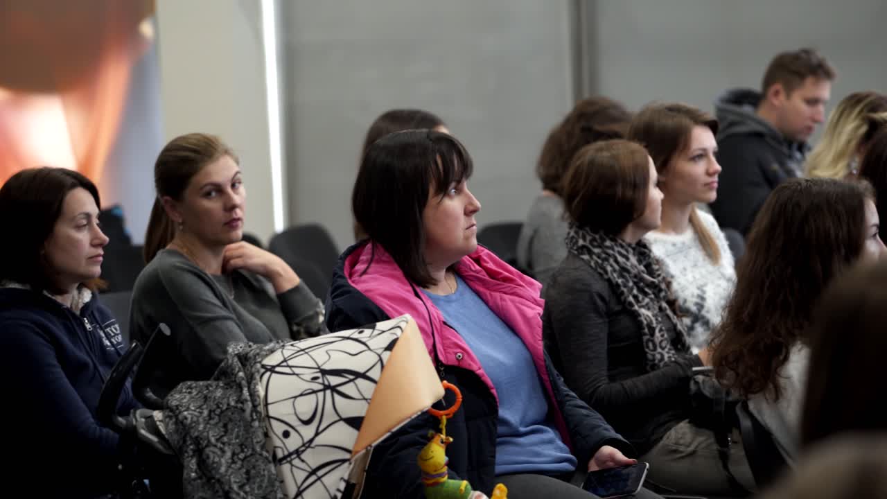 Spectators in the public seminar. People sitting in the conference hall and listening to speaker. Listeners are waiting for beginning of a lecture.