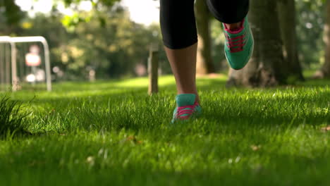 mujer corriendo por el césped