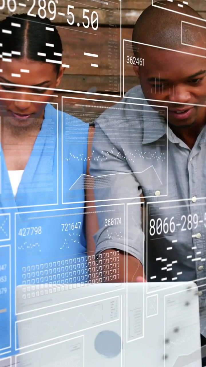 Analyzing HUD overlay appearing, team in blue blouse, grey top checking laptop and papers at table