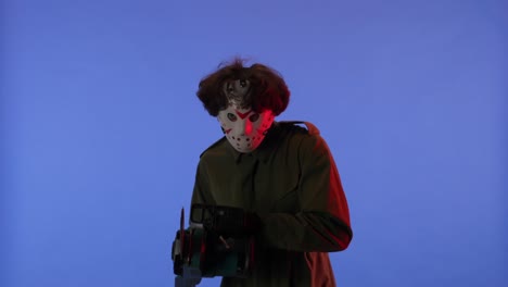 man in white mask with chainsaw in hands on blue background image of maniac jason voorhees from