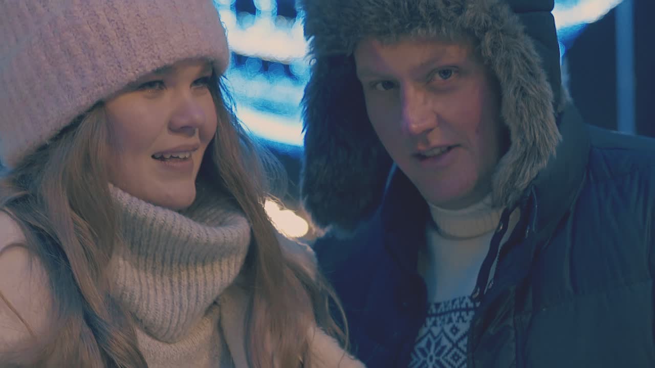 행복한 젊은 커플은 휴일 박람회에서 함께 시간을 보낸다