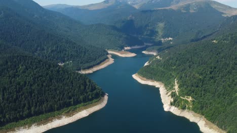 video de avión no tripulado cinematográfico 4k volando sobre una presa y un lago en rumania entre un hermoso bosque