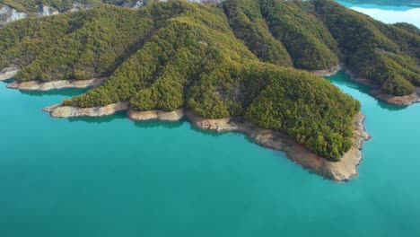 aerial view of a serene lake surrounded by lush green mountains