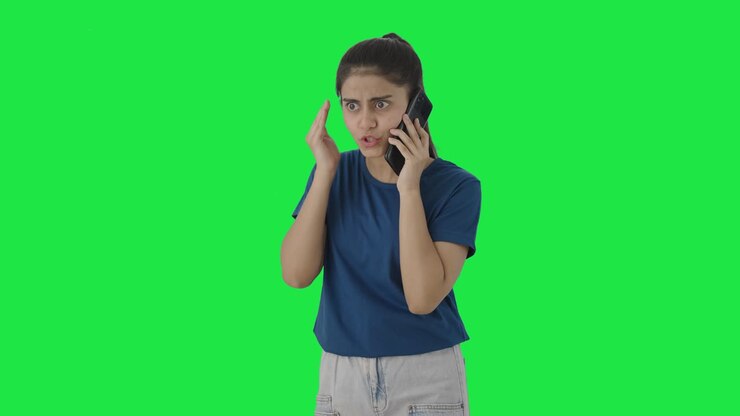 una adolescente india enojada gritando a alguien en la pantalla verde de la llamada
