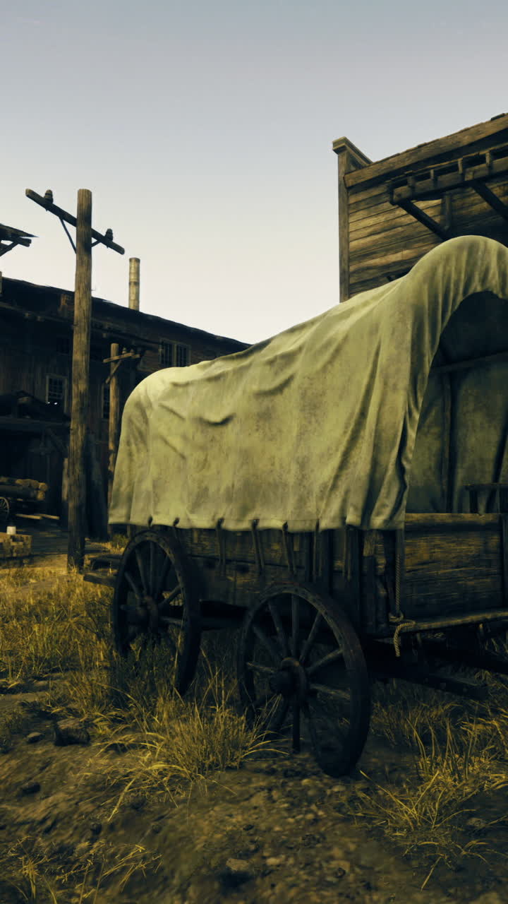 Old wooden wagon near rustic buildings in a dusty setting at sunset