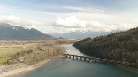 Vista-Aérea-De-Un-Río-En-El-Valle-Rodeado-Por-Un-Paisaje-Montañoso-Canadiense