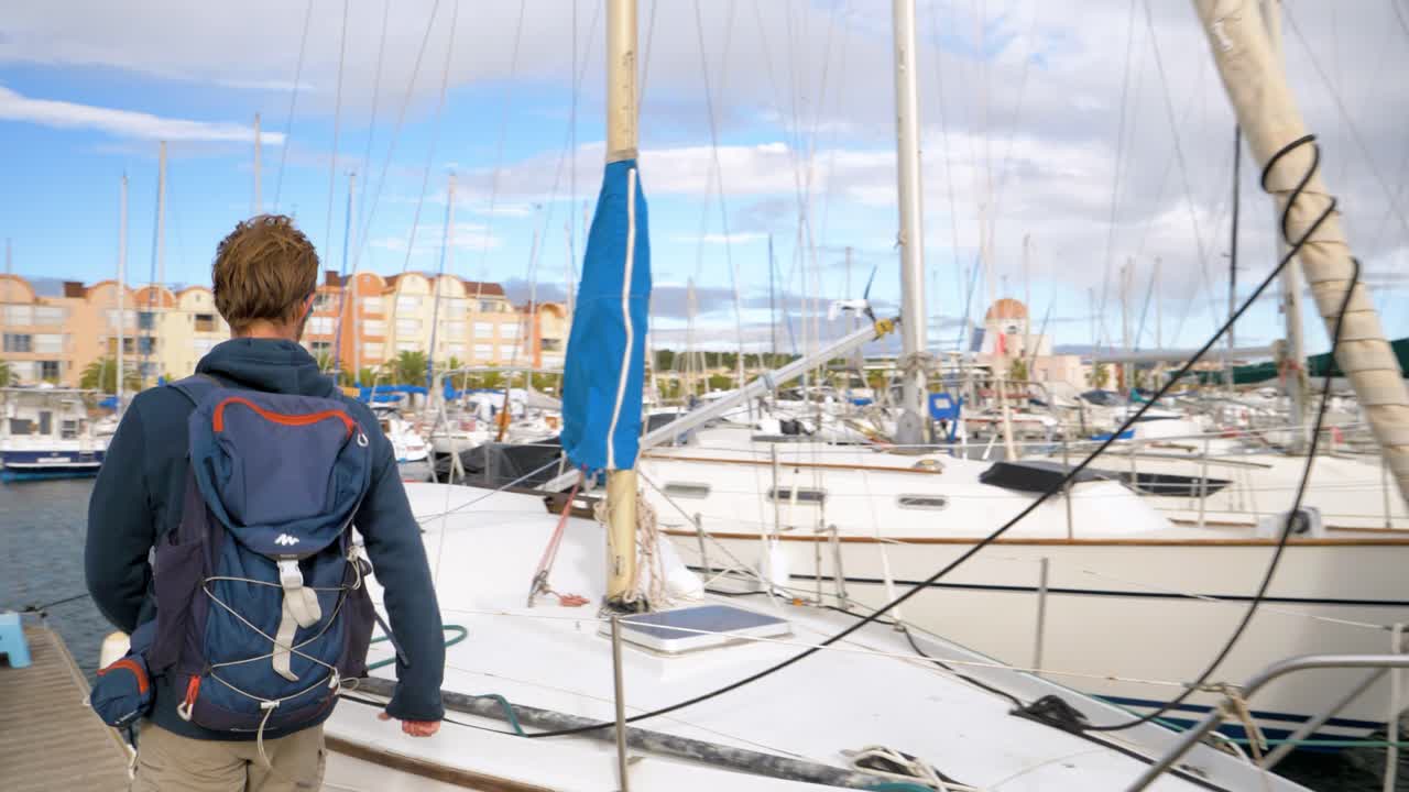 Zeitlupenaufnahme eines Kapitäns, der sich auf seine im Yachthafen liegende Yacht zieht