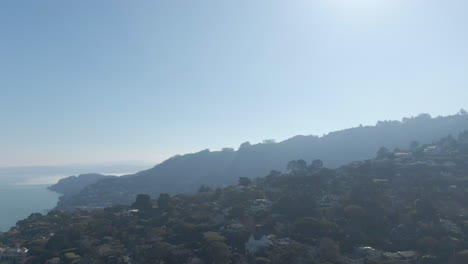 flight over the hills of northern california with a hazy san francisco skyline in the distance