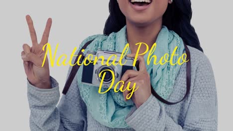 animation of happy asian woman holding camera over national photo day text