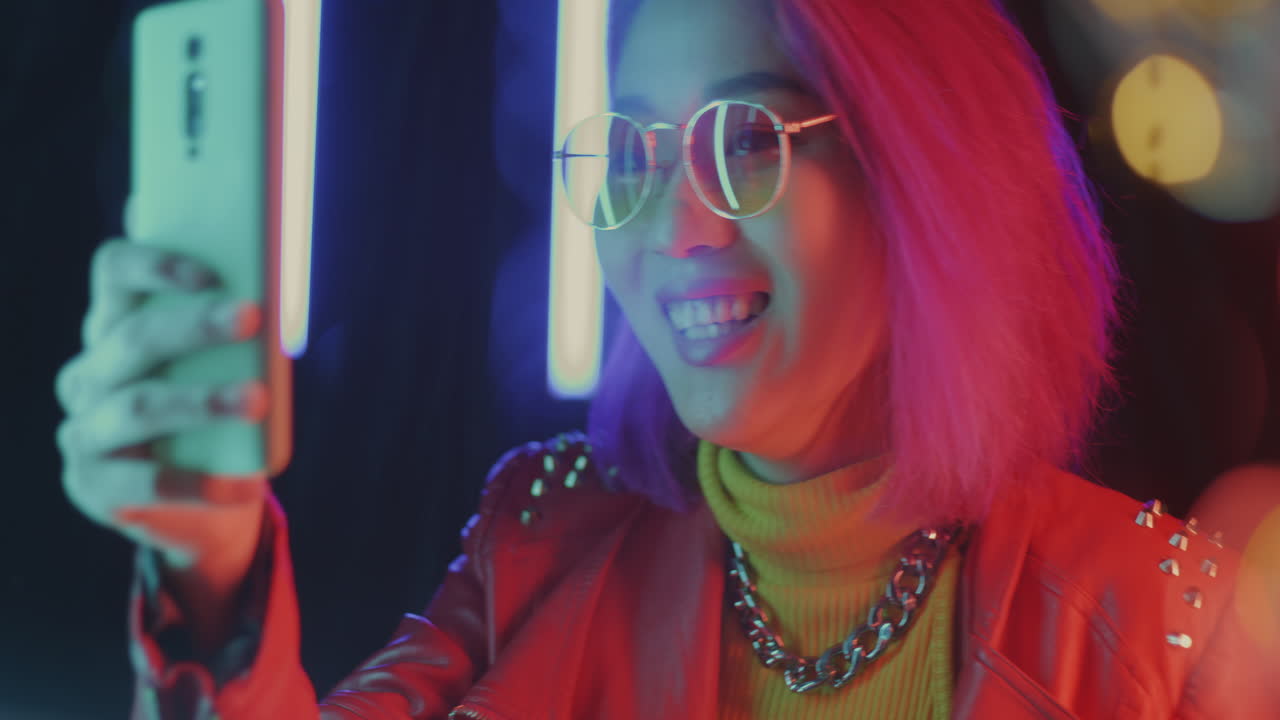 Stylish Woman Using Smartphone in Neon Lights