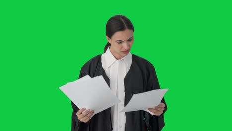 abogada india estresada y tensa leyendo archivos de casos pantalla verde
