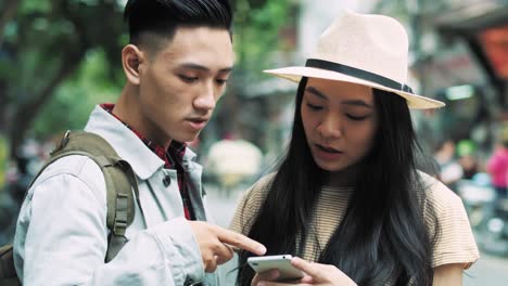 Handheld-view-of-Vietnamese-couple-of-tourists-choosing-the-best-path-for-travel