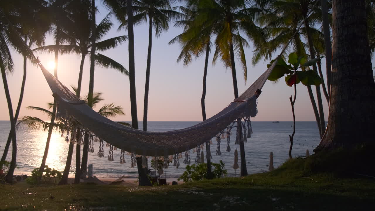 puesta de sol tropical en la playa con hamaca