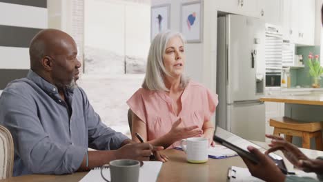 Happy-senior-diverse-couple-with-african-american-female-friend-talking-about-work