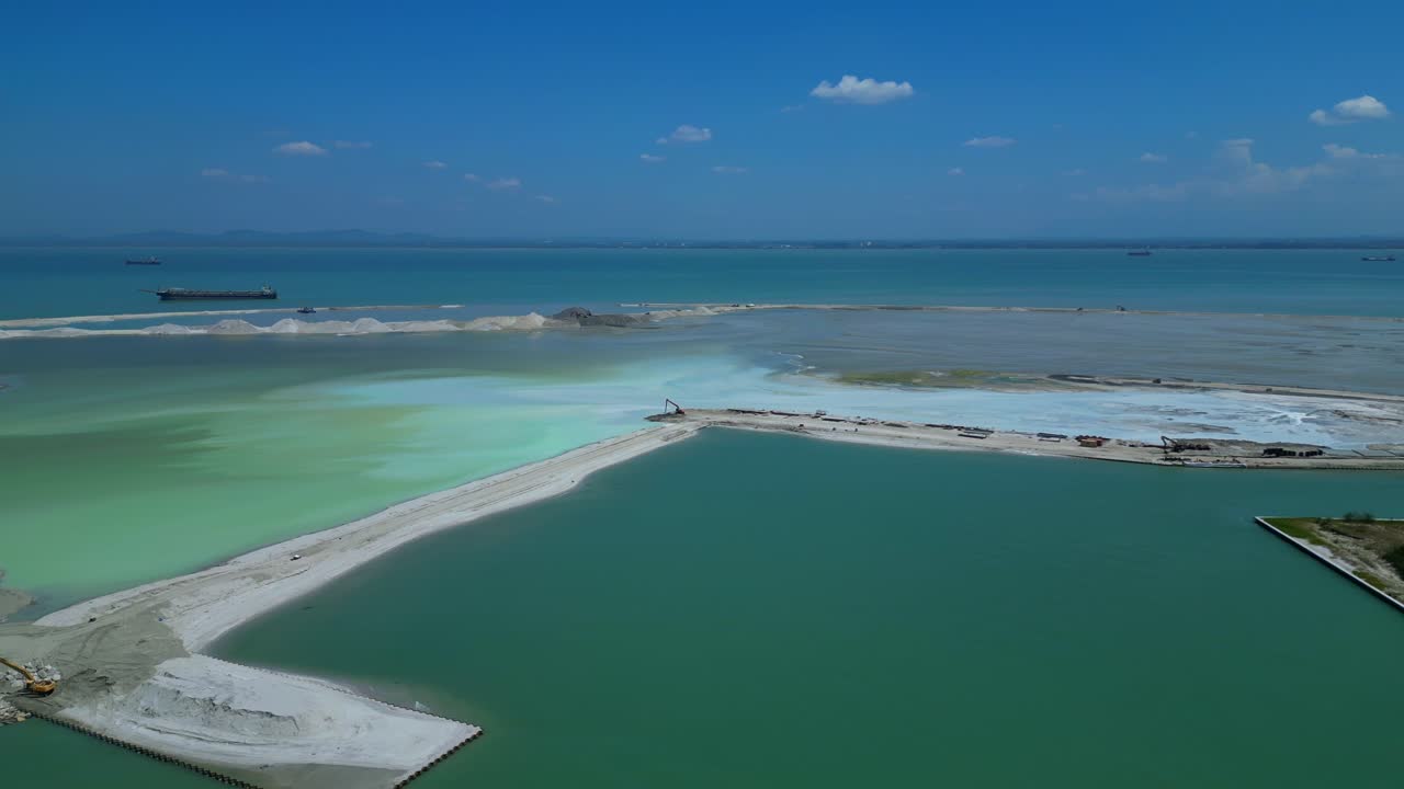 Vue aérienne d'un projet de remblaiement terrestre à grande échelle en mer.