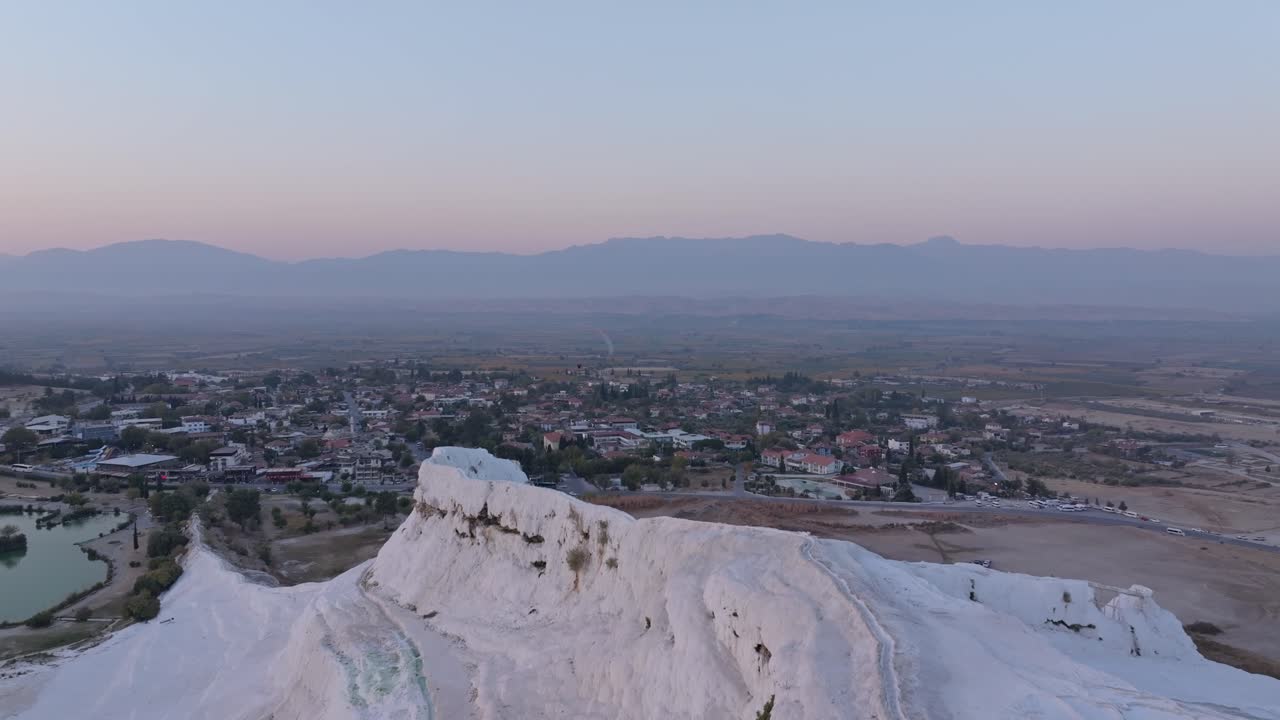 Pamukkale travertenleri, ilk ışıklarla ve baş üstünde süzülen yamaç paraşütleriyle.