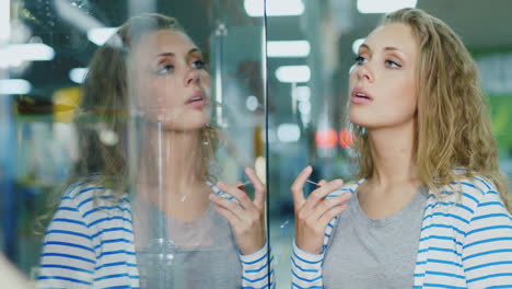 Sad-Young-Woman-Stands-At-The-Storefront-In-The-Hands-Of-Her-Payment-Card-She's-Upset-Hd-Video