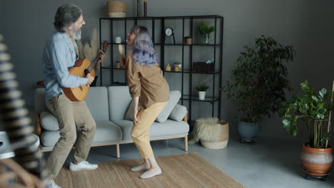 happy couple singing and dancing in living room
