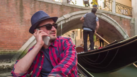 man talking on phone in a gondola in venice