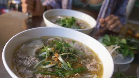 sexy vietnamese girl in bikini eating traditional pho beef noodle soup in local vietnamese restaurant