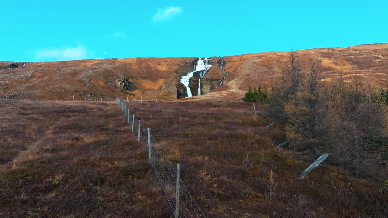 volando por una ladera en islandia en otoño para revelar una cascada triple