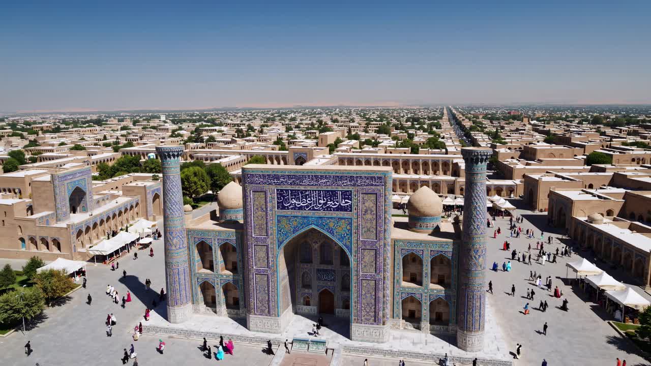 Aerial video captures a historic mosque with intricate tilework, surrounded by a sprawling cityscape