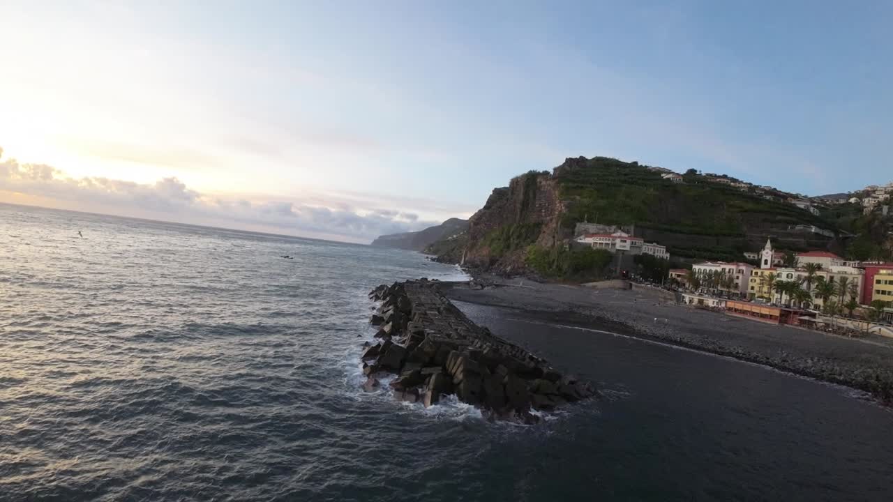 Primo piano di un molo costiero e della costa con edifici a Ponta do Sol, Madeira