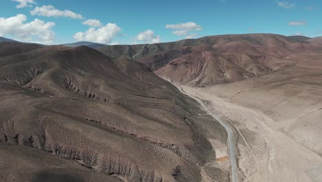 Paisaje-Desolado-Y-árido-Atravesado-Por-Una-Carretera-Pavimentada-Que-Se-Dirige-A-Salinas-En-La-Provincia-De-Jujuy,-Argentina