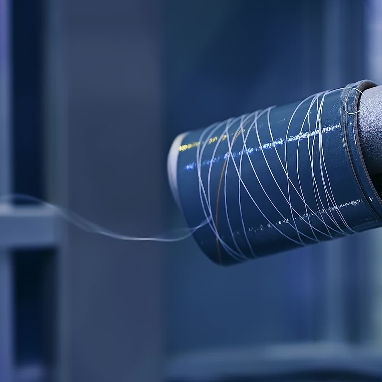 White thread is unwinding from the sewing bobbin. Almost finished spool of thread at the diaper enterprise close up