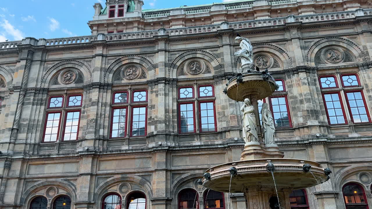 Vienna, Austria - June 9, 2025: Vienna's historic fountain. Tourists admire a beautiful fountain set against a grand building in Vienna, capturing the essence of European travel