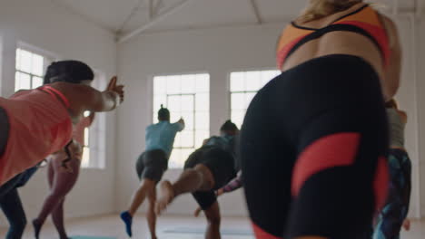 Hermoso-Instructor-De-Clase-De-Yoga-Enseñando-A-Un-Grupo-Joven-Practicando-Pose-De-Guerrero-Disfrutando-De-Un-Estilo-De-Vida-Saludable-Haciendo-Ejercicio-En-El-Estudio-Al-Amanecer.