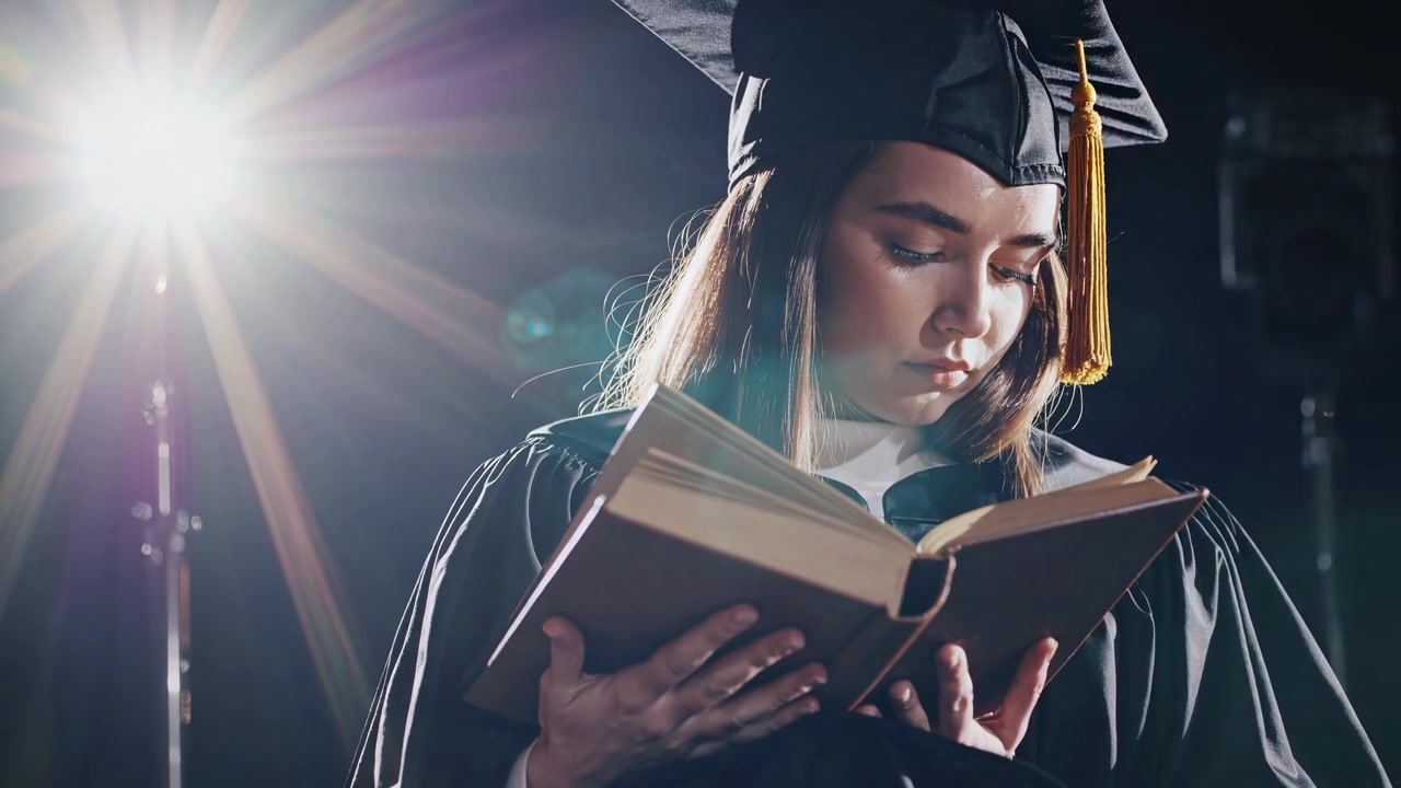 Young Graduate Woman Reading a Book Under Dramatic Spotlight