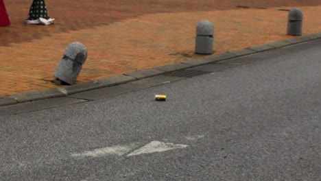 one soft drink can rolling down street into gutter