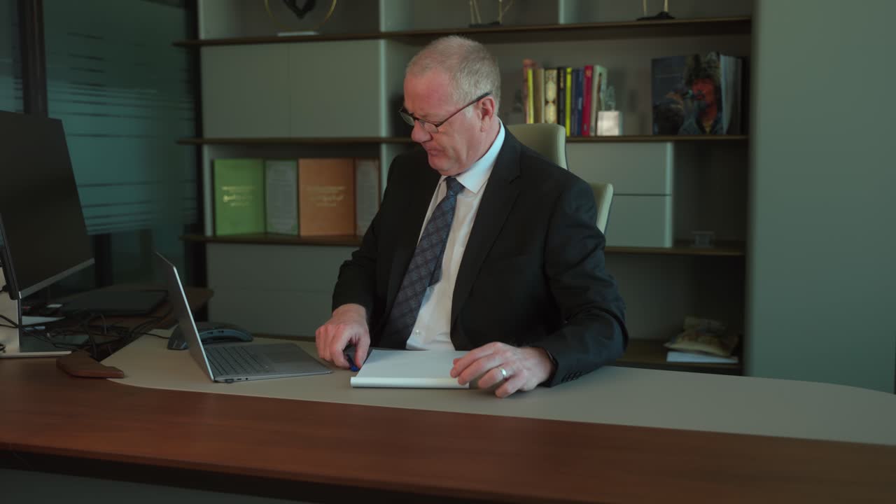 Businessman at his office desk needs an idea for a deadline but can't come up with one, loses his temper and wads up a piece of paper and throws it in frustration - slow motion