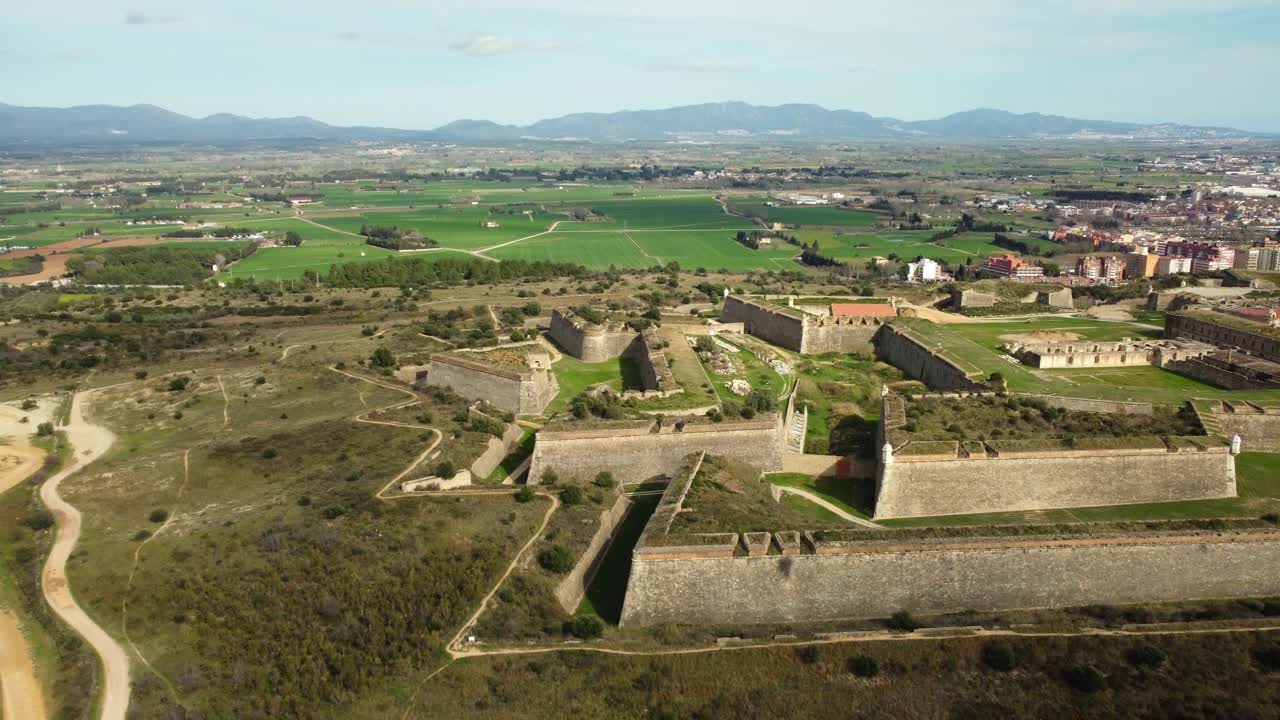 Vista aerea di una fortezza storica con uno sfondo paesaggistico e urbano