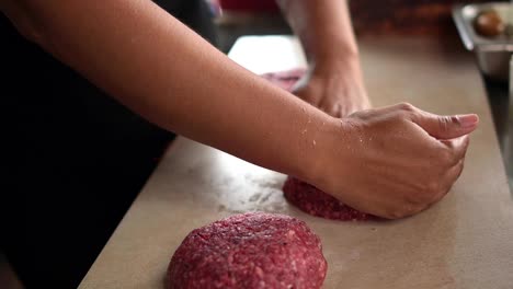 kulturkoch, der koteletts aus rohem hackfleisch zubereitet