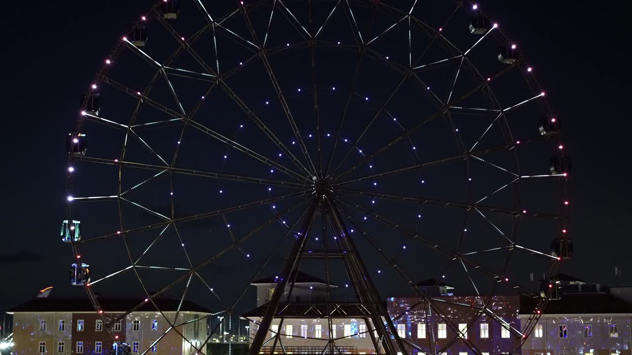 가속화 된. 밤 하늘에 반하여 빛나는 다채로운 불빛으로 페리스