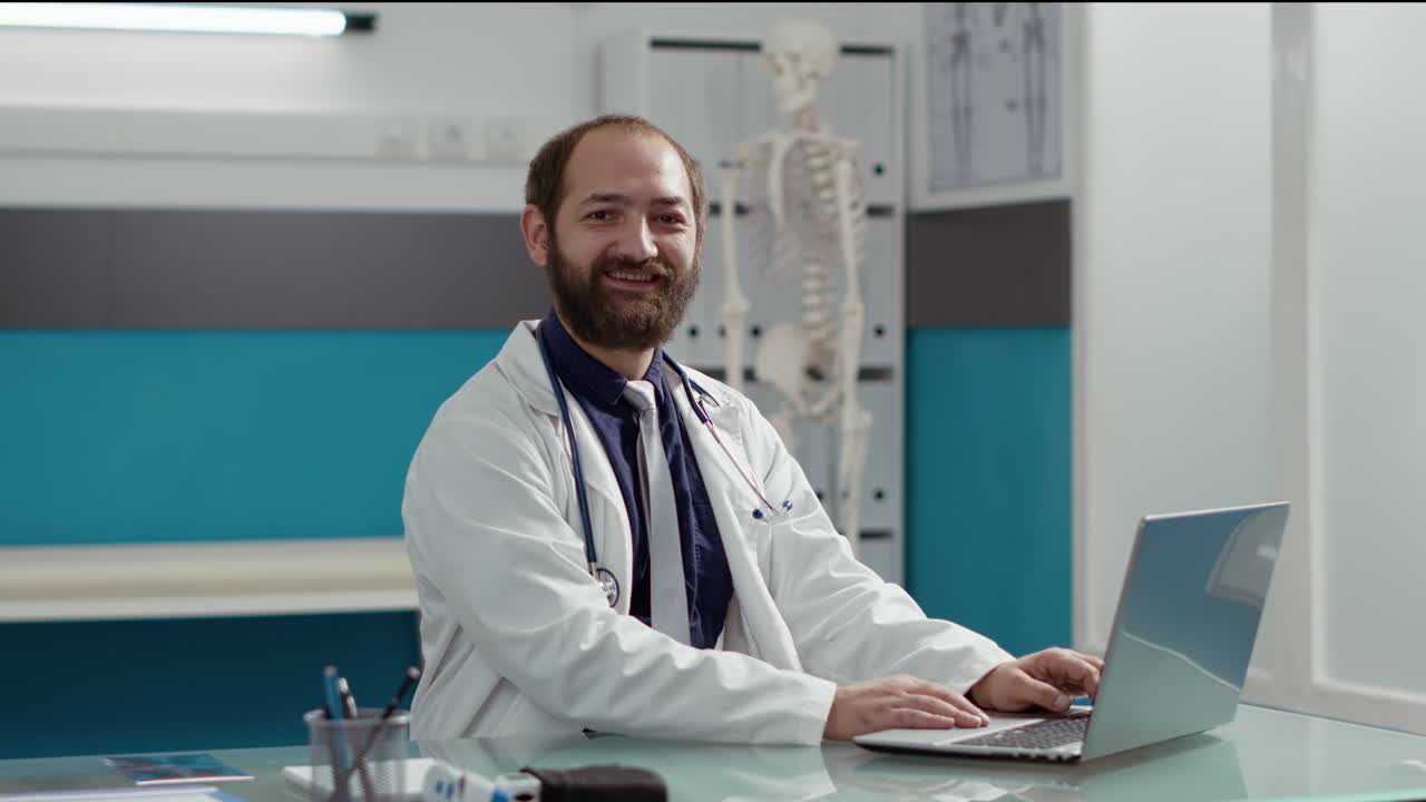 Portrait of general practitioner working on laptop to plan checkup visit